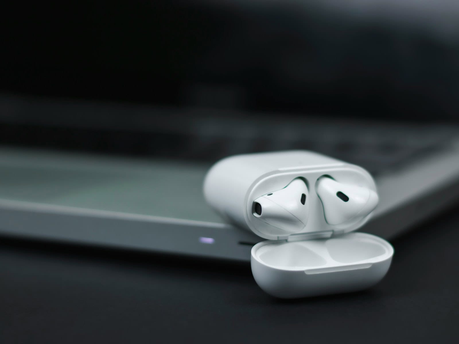 white apple earpods on black surface