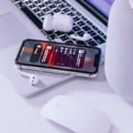 iPhone on Macbook beside magic mouse