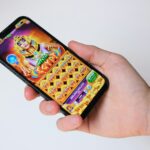 A hand holds a phone with an egyptian-themed game.