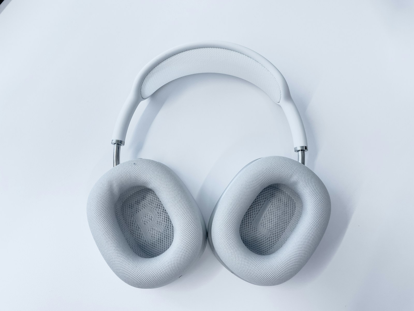 white wireless headphones on white surface