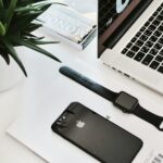space black stainless steel Apple Watch on table beside the MacBook Pro