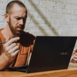a man sitting at a table using a laptop computer