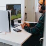 a person wearing a mask and sitting at a desk